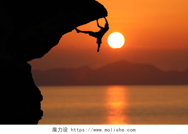 黄昏下攀登悬崖的极限运动员对美丽的红色天空一元的悬崖上的登山者的剪影